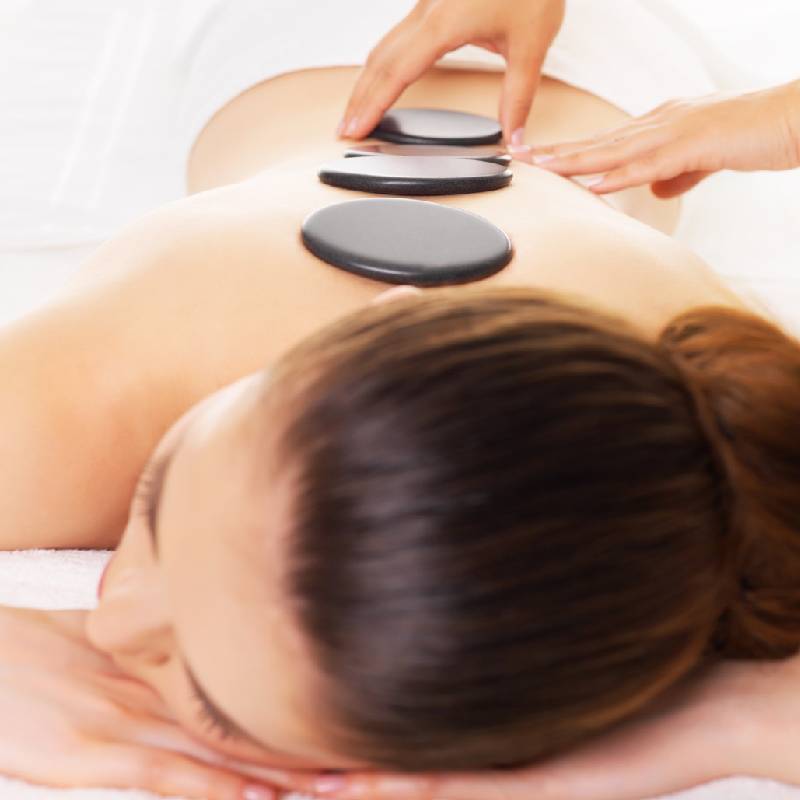 Masaje descontracturante con posicionamiento de piedras calientes